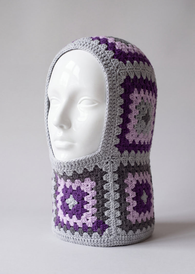 Grey and purple granny square balaclava on a display head, open face and deep neck section — handmade by Ana Chic