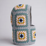 Teal and mustard granny square balaclava standing on its own, back view of the hood — handmade by Ana Chic