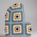 Teal and mustard granny square balaclava laid flat, side view of the hood — handmade by Ana Chic