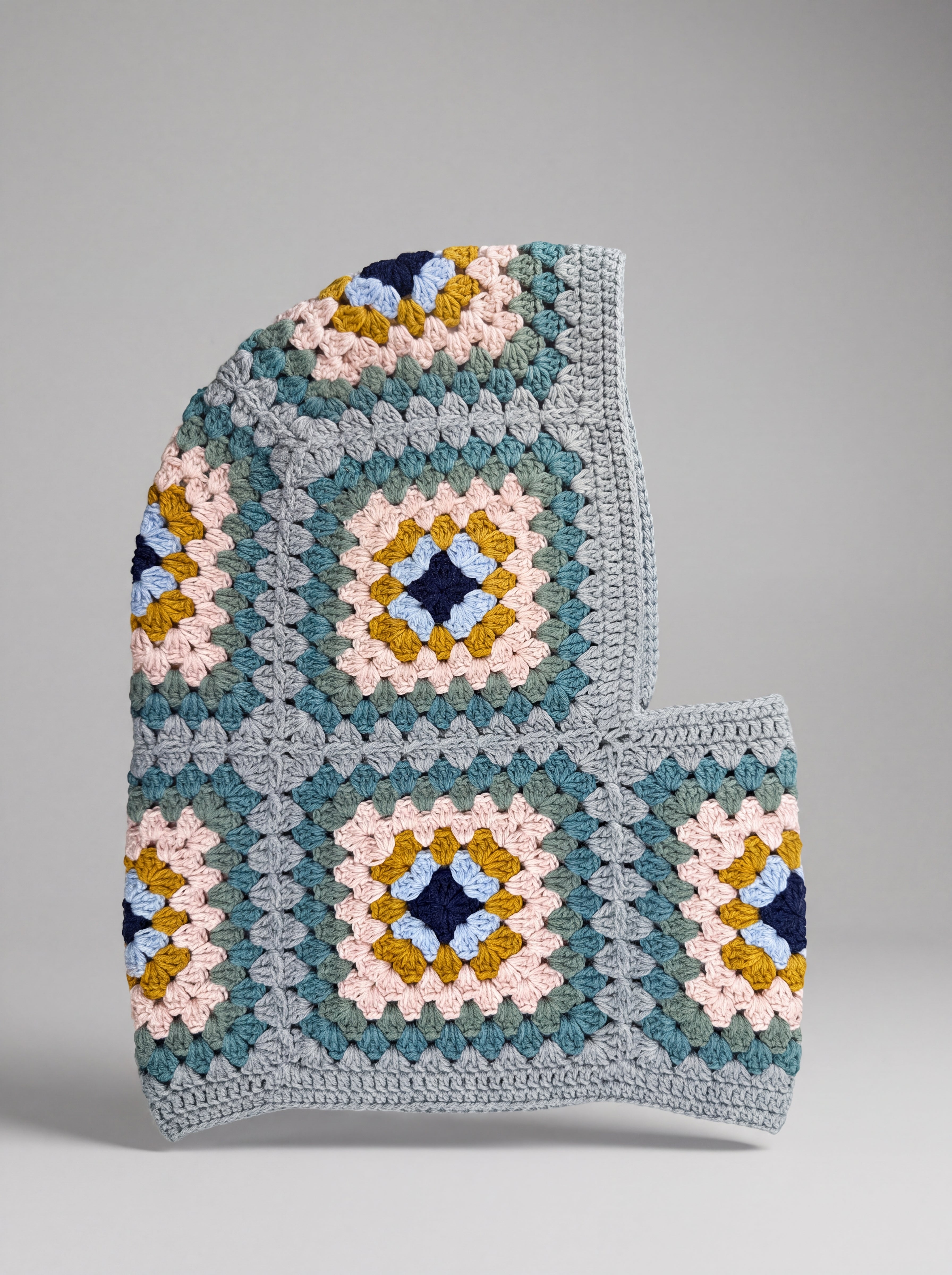 Teal and mustard granny square balaclava laid flat, side view of the hood — handmade by Ana Chic