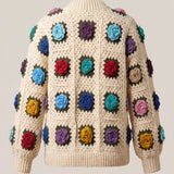 Back of cream granny-square cardigan with a raised crochet rose in every square and a deep ribbed hem — handmade by Ana Chic