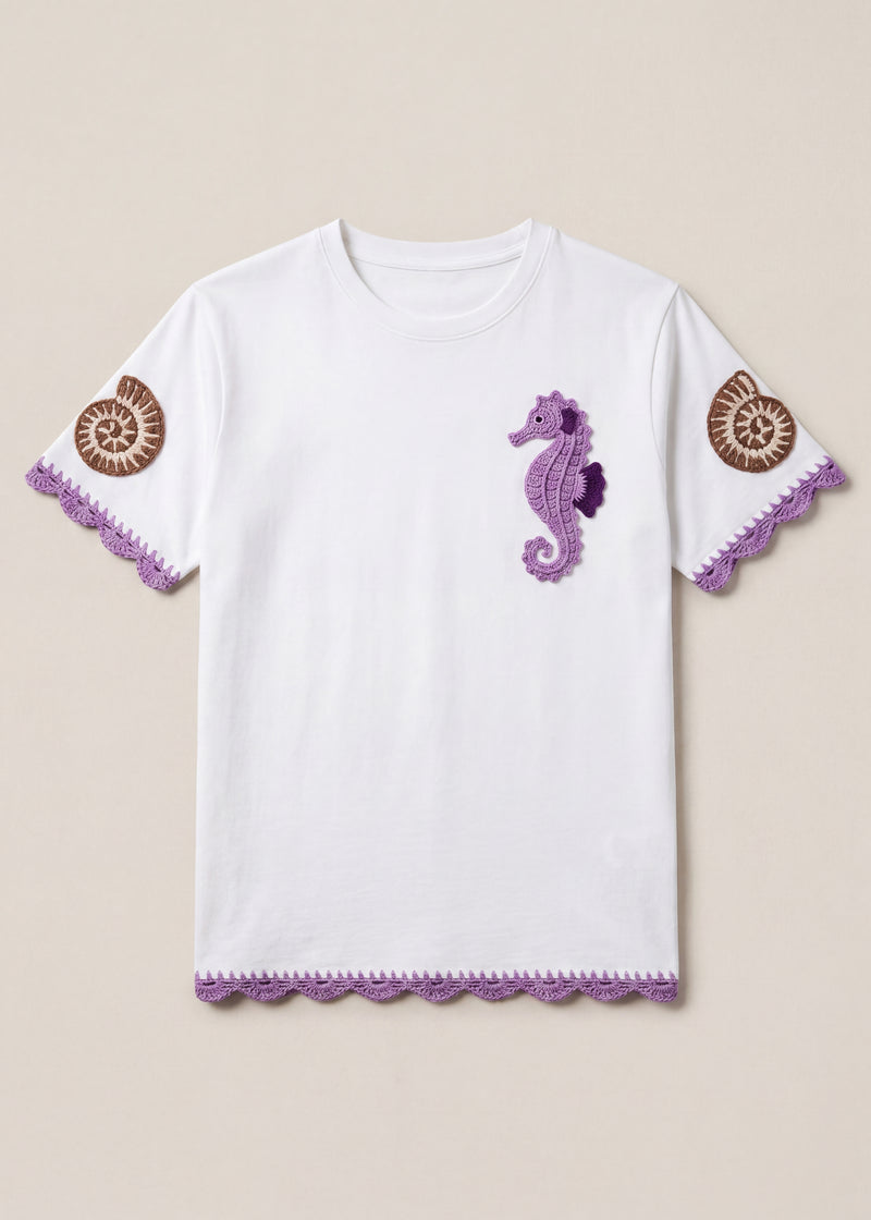 White cotton tee with a lilac crochet seahorse, spiral shell sleeves and scalloped hems, front view - handmade by Ana Chic