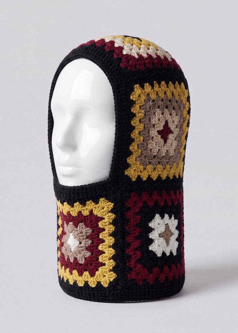 Black and burgundy granny square balaclava on a display head, open face and deep neck section — handmade by Ana Chic