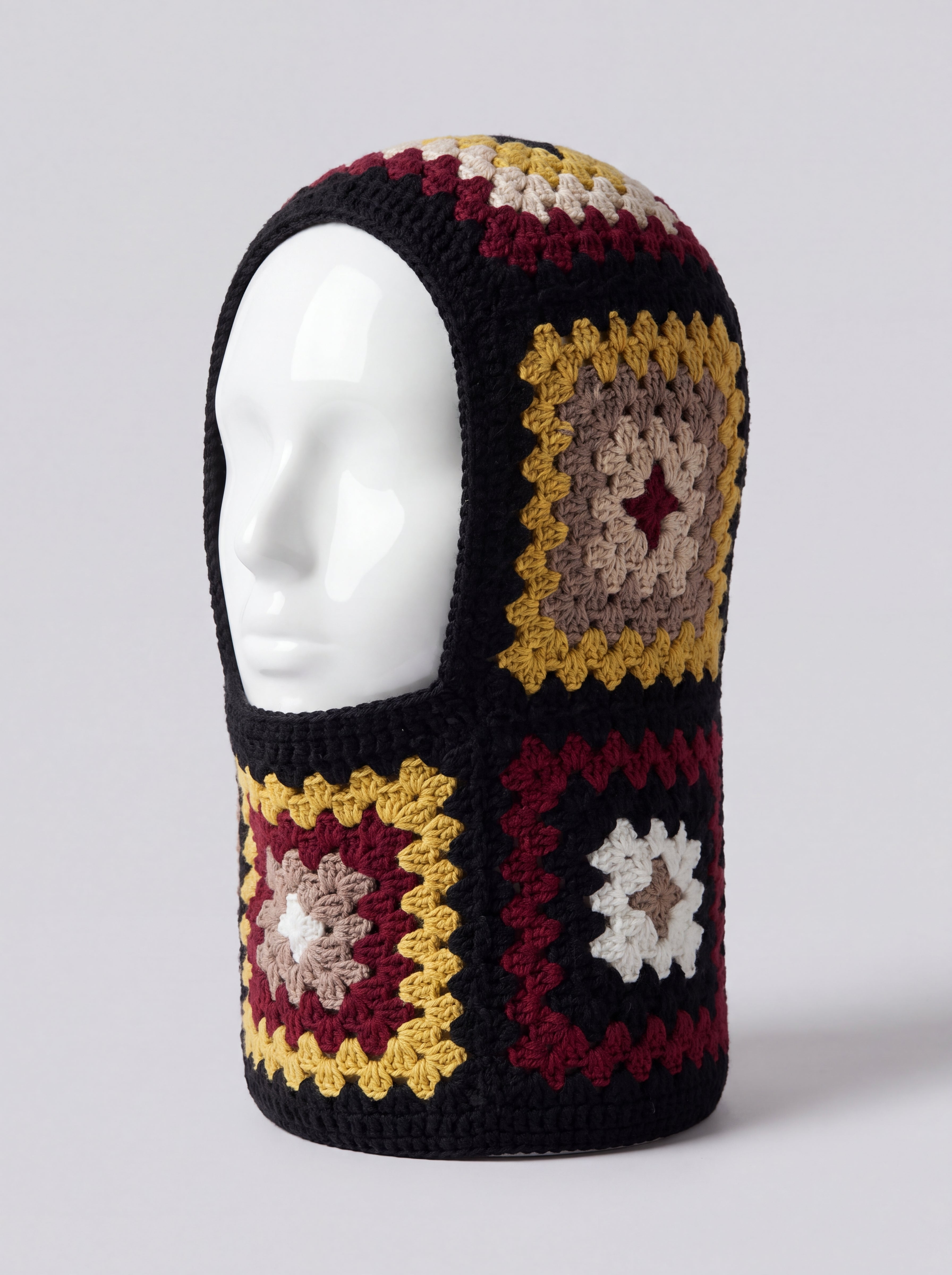 Black and burgundy granny square balaclava on a display head, open face and deep neck section — handmade by Ana Chic