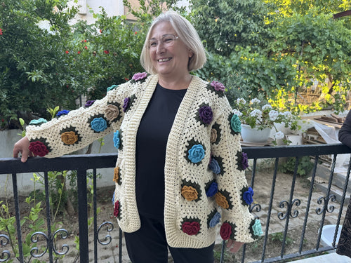 Customer in a cream floral crochet cardigan in a garden