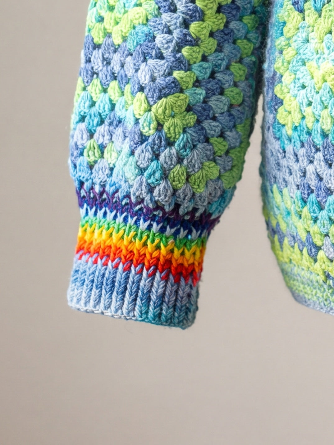 Rainbow-striped ribbed cuff on a granny square crochet cardigan — handmade by Ana Chic