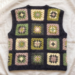 Green granny square crochet vest, back, laid flat on linen