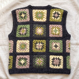 Green granny square crochet vest, back, laid flat on linen