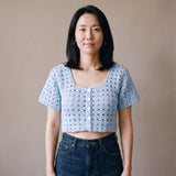 Ivory hand-crocheted organic cotton cropped top in baby blue, worn buttoned with five pearl buttons - Ana Chic