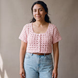 Ivory hand-crocheted organic cotton cropped top in baby pink, worn buttoned with five pearl buttons - Ana Chic