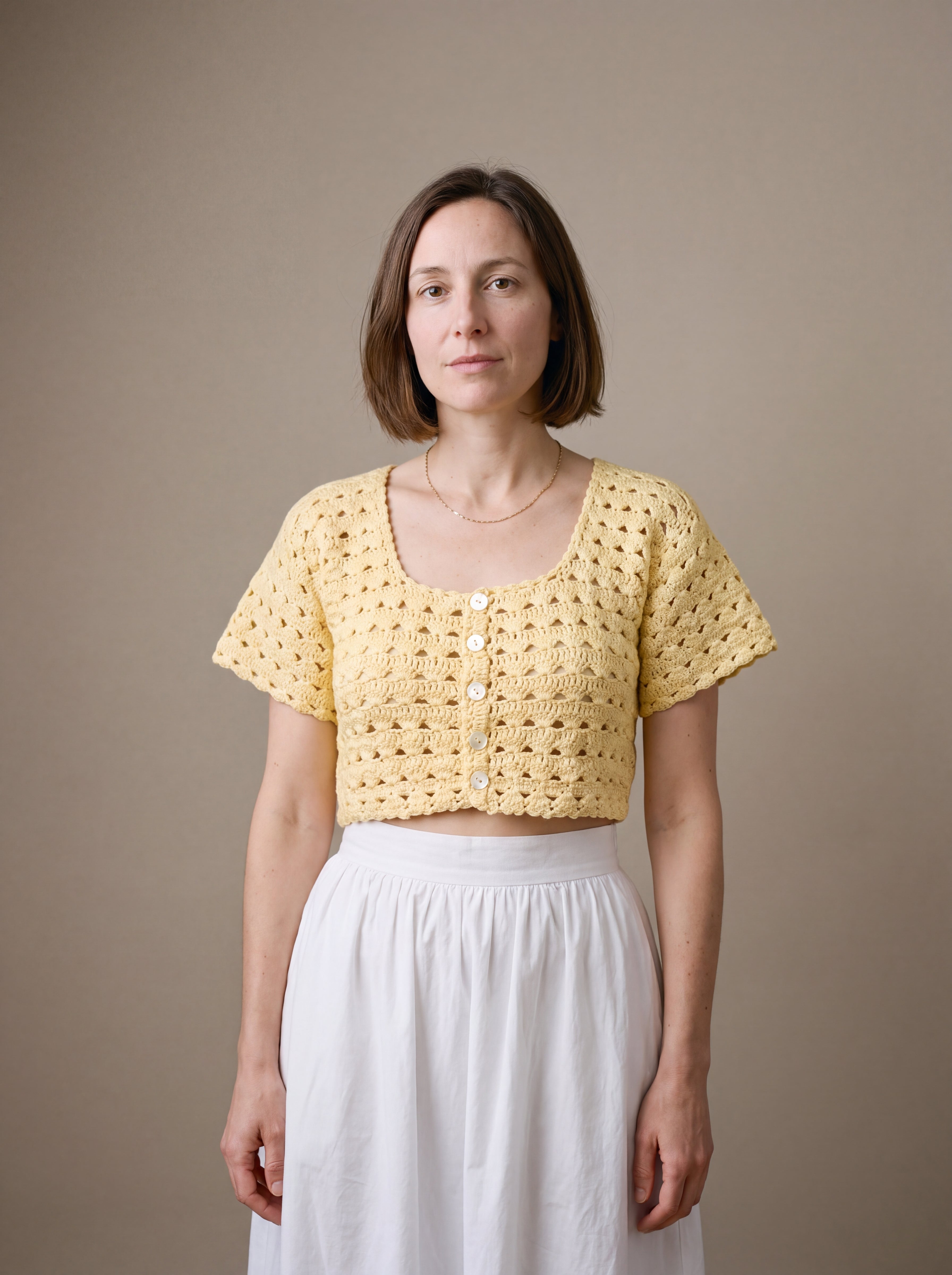 Ivory hand-crocheted organic cotton cropped top in butter yellow, worn buttoned with five pearl buttons - Ana Chic