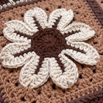 Macro of a raised hand-crocheted flower square on the Sampler Cardigan in Brown