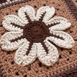 Macro of a raised hand-crocheted flower square on the Sampler Cardigan in Brown