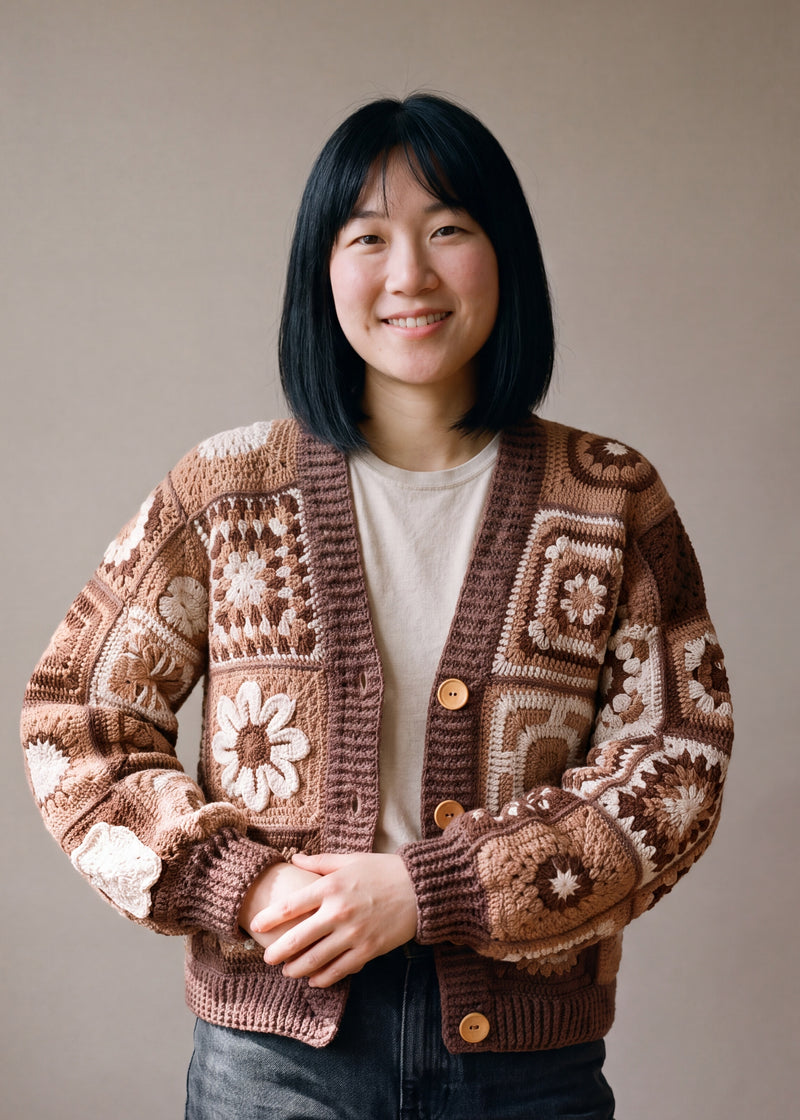 Woman wearing the Sampler Cardigan in Brown, a hand-crocheted granny-square cardigan, over a plain t-shirt and jeans