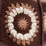 Macro of a hand-crocheted square with a ring of popcorn bobbles on the Sampler Cardigan in Brown