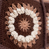 Macro of a hand-crocheted square with a ring of popcorn bobbles on the Sampler Cardigan in Brown