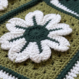 Macro of a raised hand-crocheted flower square on the Sampler Cardigan in Forest Green