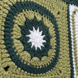 Macro of a hand-crocheted concentric star square on the Sampler Cardigan in Forest Green