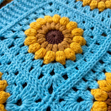Close-up of the raised sunflower motif on turquoise crochet - handmade by Ana Chic