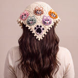 Back view of the large crochet bandana worn over long dark hair, five cat faces and a black paw on cream granny squares — handmade by Ana Chic