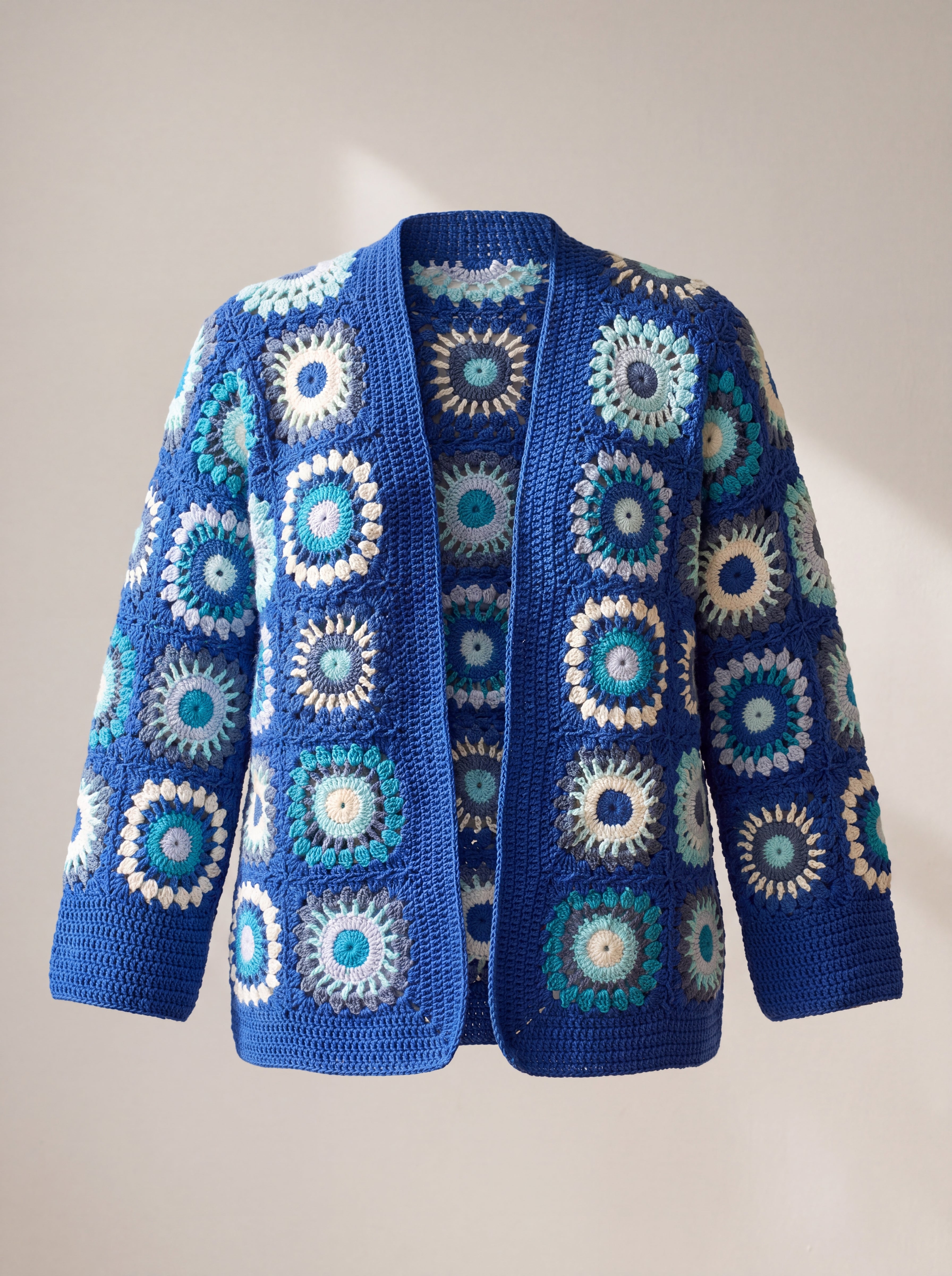 Front of the Mosaic Cardigan in cobalt and aqua, ringed puff-stitch squares in sea blues and cream on cobalt - handmade by Ana Chic