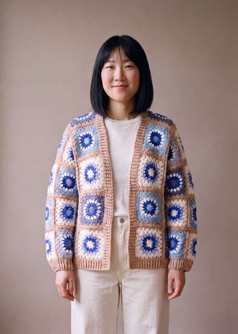 Patchwork cardigan in blue and cream granny squares with camel-beige bands, worn open over a white top - handmade by Ana Chic