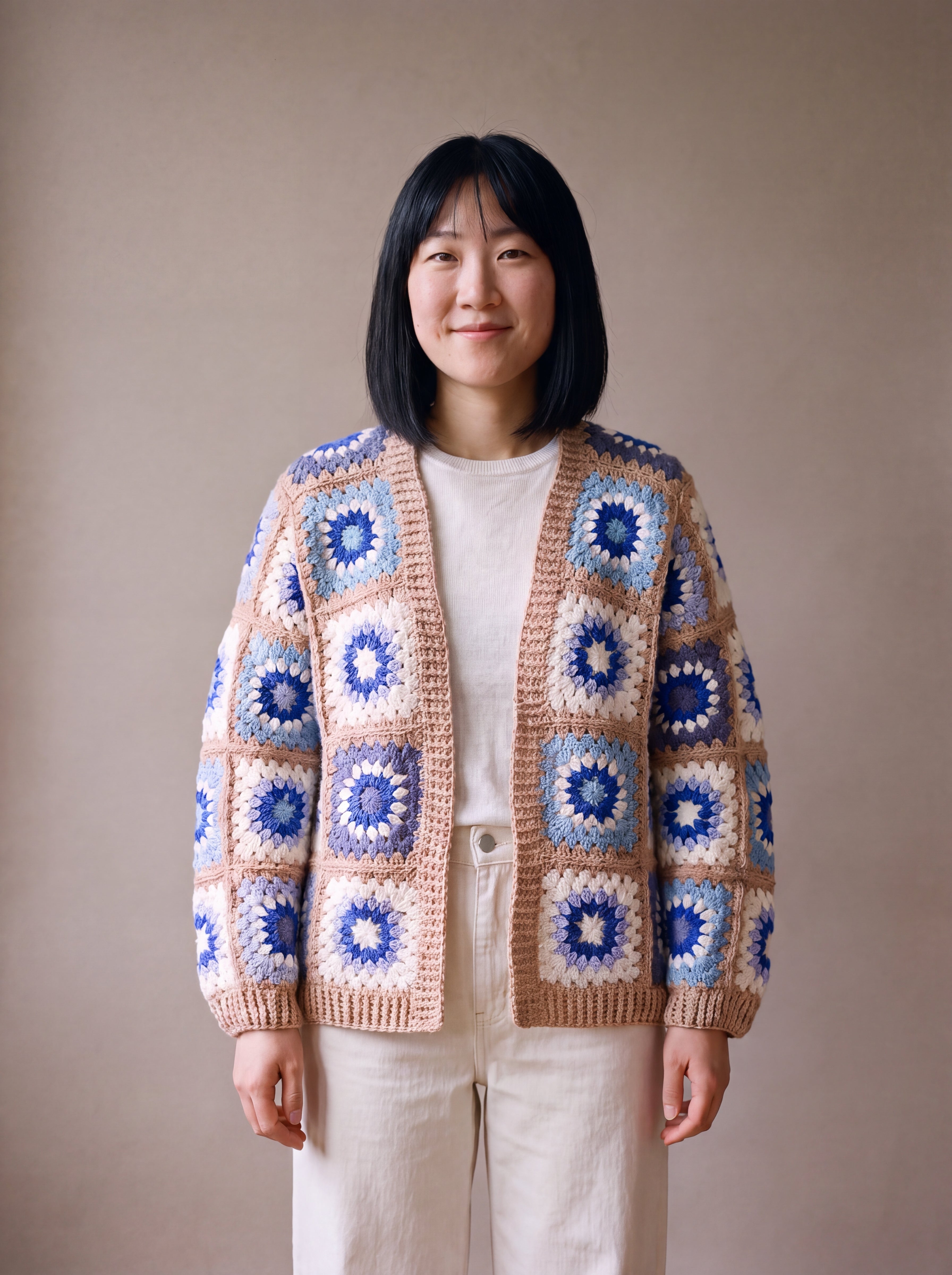 Patchwork cardigan in blue and cream granny squares with camel-beige bands, worn open over a white top - handmade by Ana Chic