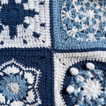 Close-up of four different hand-crocheted squares on the Sampler Long Cardigan: compass star, snowflake, shell hexagon and popcorn disc