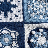 Close-up of four different hand-crocheted squares on the Sampler Long Cardigan: compass star, snowflake, shell hexagon and popcorn disc