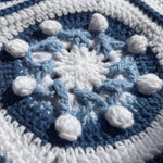 Macro of a hand-crocheted square with eight raised white popcorn bobbles on a navy disc, Sampler Long Cardigan
