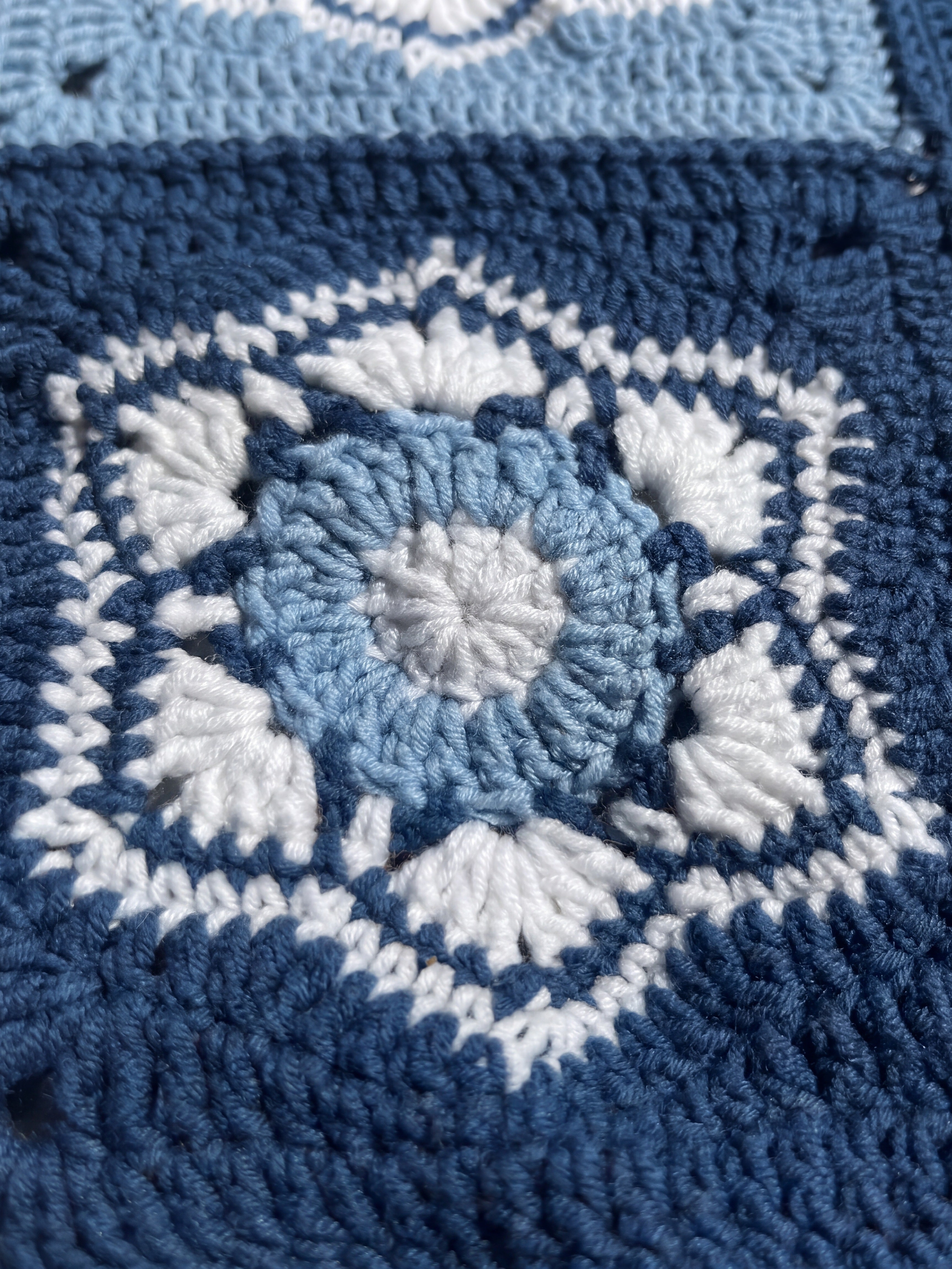 Macro of a hand-crocheted square with six white shell fans inside a hexagon on navy, Sampler Long Cardigan