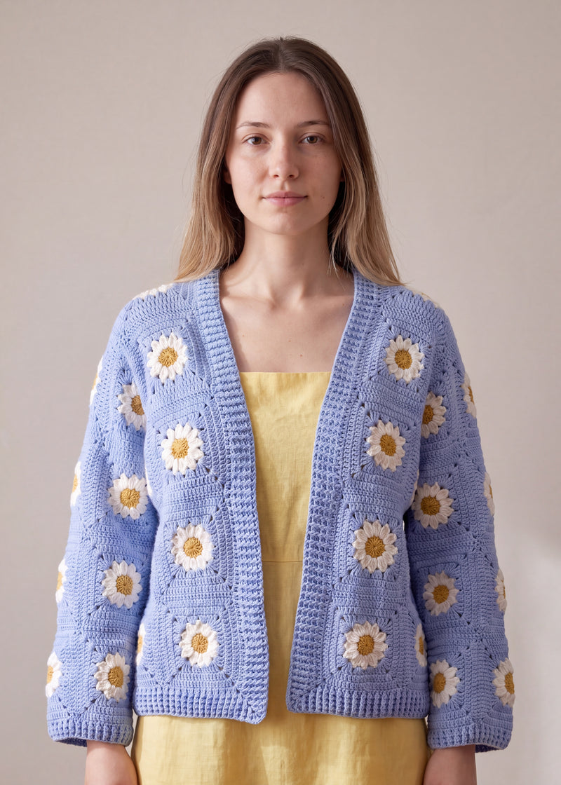 Sky Daisy sky blue daisy granny square crochet cardigan worn open over a yellow linen dress