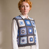 Blue granny square crochet vest worn over a white shirt