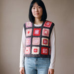 Rose granny square crochet vest worn over a white long-sleeve tee