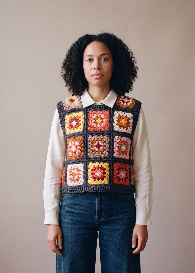 Terracotta granny square crochet vest worn over an ecru linen shirt