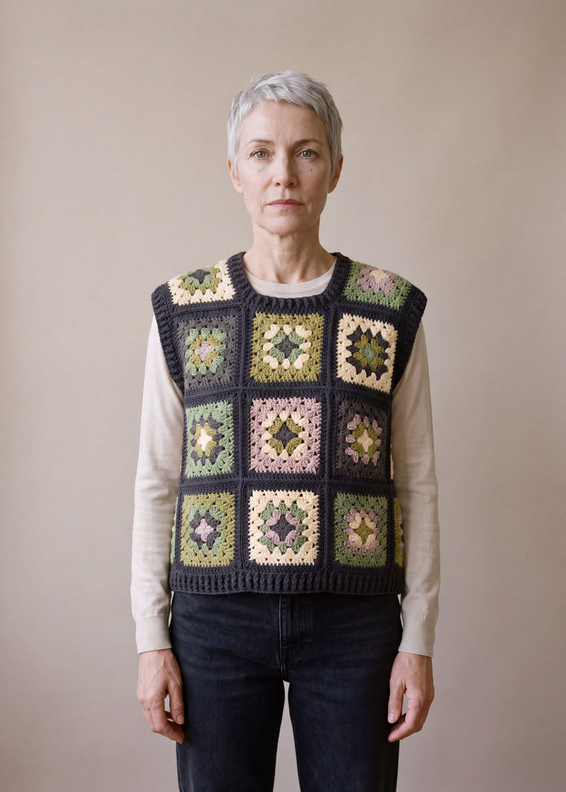Green granny square crochet vest worn over a beige long-sleeve top