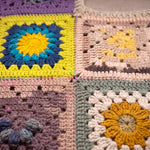 Close-up of the Lanes Spirit Vest: hand-crocheted squares, each one a different design
