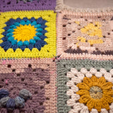 Close-up of the Lanes Spirit Vest: hand-crocheted squares, each one a different design