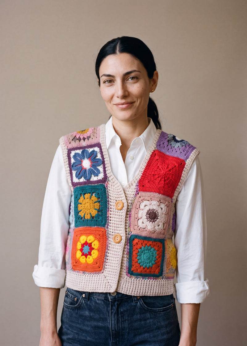 Woman wearing the Lanes Spirit Vest, a handmade granny square crochet vest, over a white shirt and dark jeans