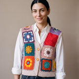 Woman wearing the Lanes Spirit Vest, a handmade granny square crochet vest, over a white shirt and dark jeans