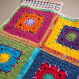 Close-up of the Confetti Vest: hand-crocheted squares, each one a different design