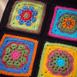 Close-up of the Electra Vest: hand-crocheted squares, each one a different design