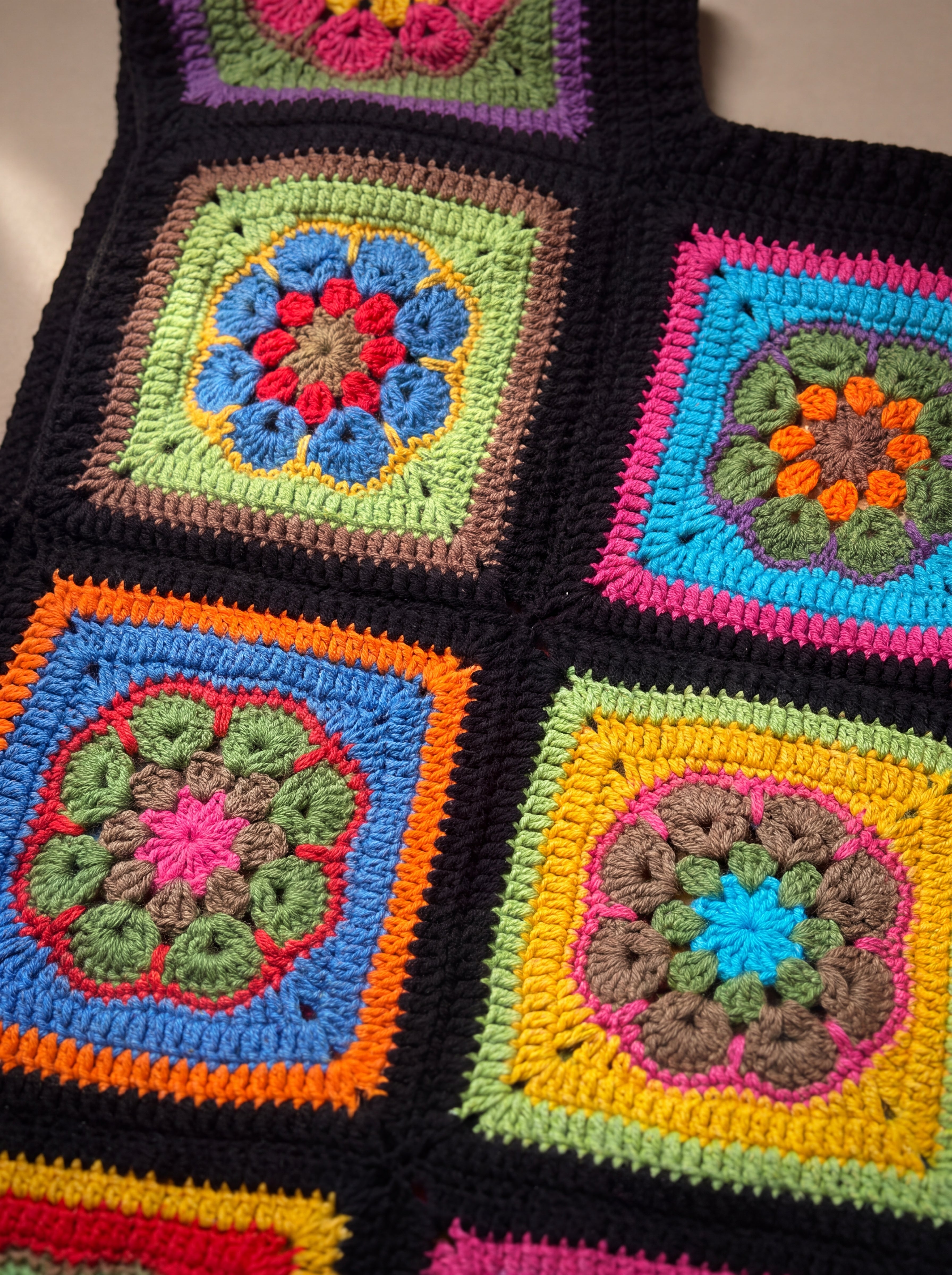 Close-up of the Electra Vest: hand-crocheted squares, each one a different design