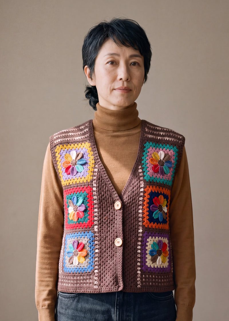 Woman wearing the Bracken Vest, a handmade granny square crochet vest, over a camel roll-neck and dark jeans