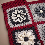 Close-up of the Cinder Vest: hand-crocheted squares, each one a different design