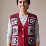 Woman wearing the Cinder Vest, a handmade granny square crochet vest, over a light grey t-shirt and black jeans
