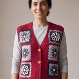 Woman wearing the Cinder Vest, a handmade granny square crochet vest, over a light grey t-shirt and black jeans